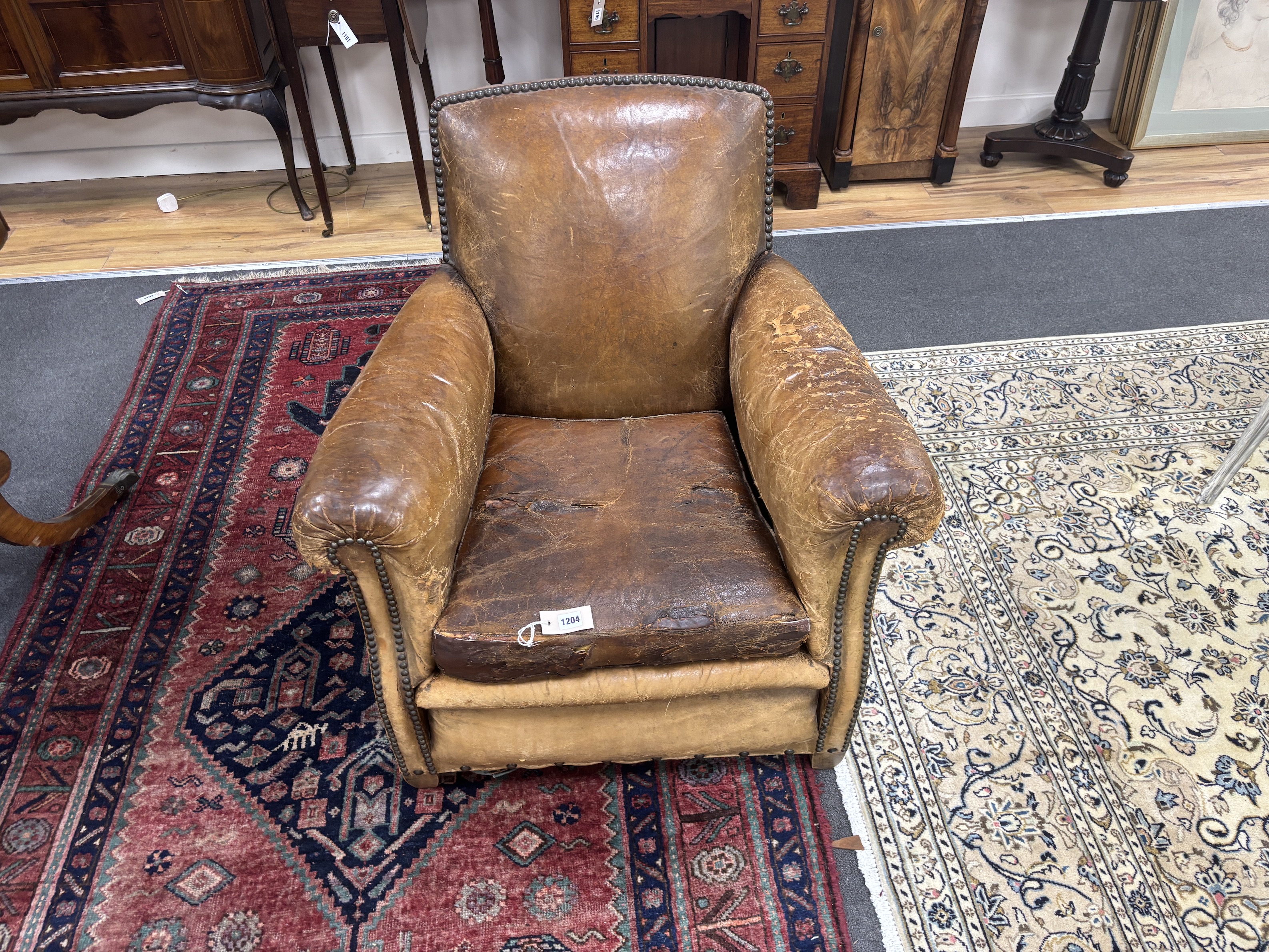 An early 20th century French studded tan leather club chair, width 64cm, depth 72cm, height 77cm